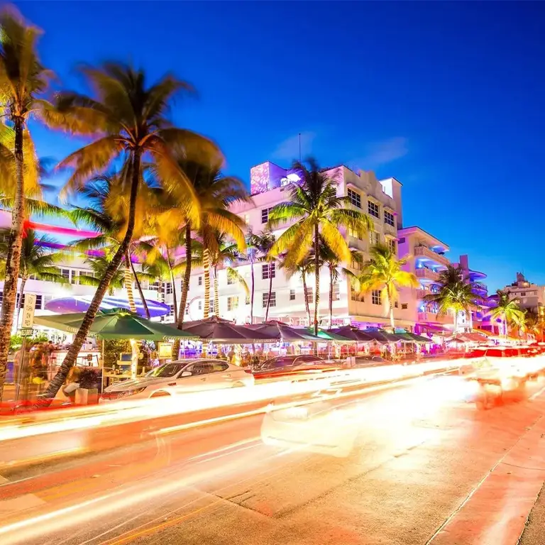 Iconic South Beach with sandy shores, palm trees, and Art Deco buildings, representing a popular destination served by Miami Premier Transportation