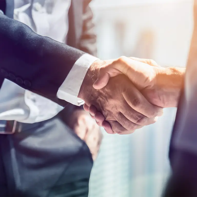 Two business executives shaking hands, symbolizing successful partnerships and collaboration through Miami Premier Transportation's business services